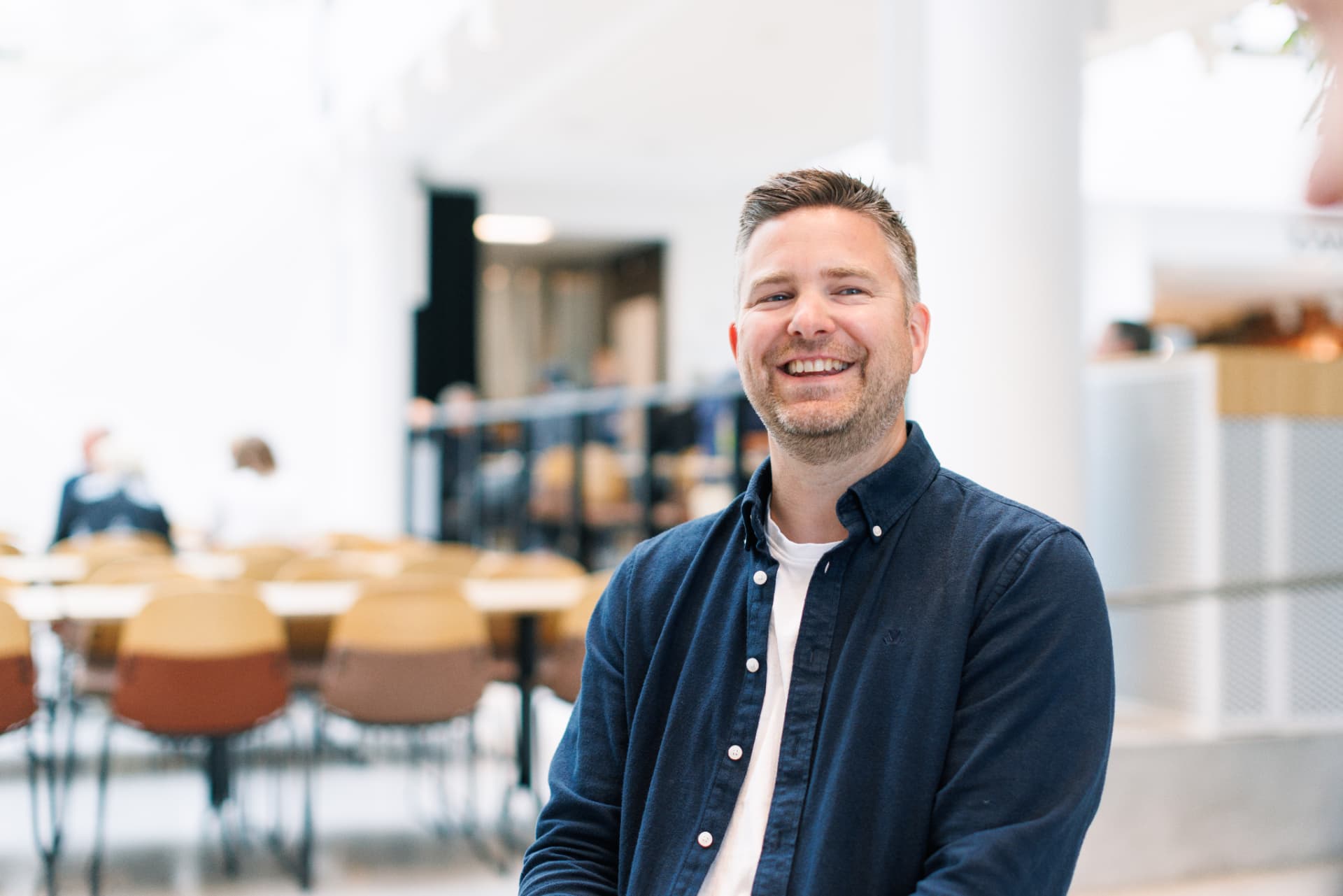 Alexander Støvik Kjølstad smiler i en lys kantine